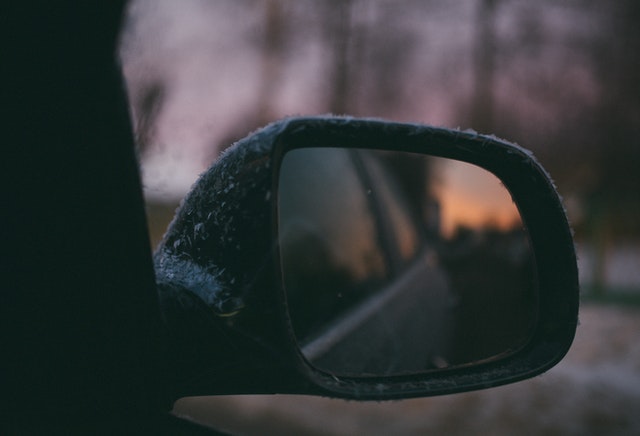 Wing mirror view of winter road
